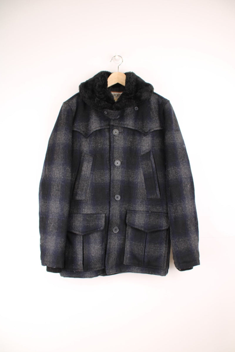 Schott Rancher coat in navy blue check with black faux fur collar, button closure, four pockets, and 'Schott' embroidered on the sleeve. 