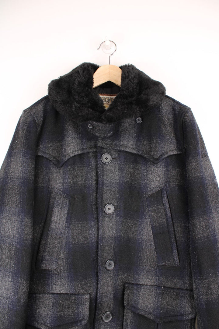 Schott Rancher coat in navy blue check with black faux fur collar, button closure, four pockets, and 'Schott' embroidered on the sleeve. 