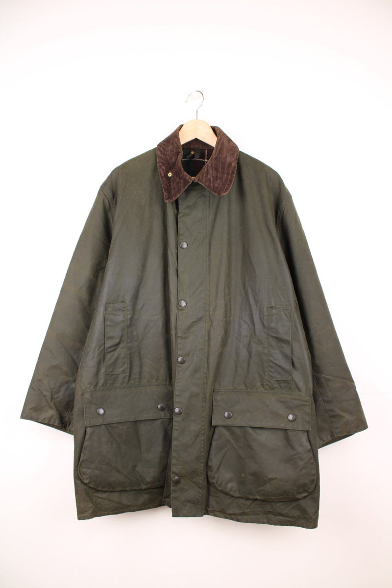 Made in England Barbour Northumbria waxed jacket in green. Tartan lined, with brown corduroy collar, zip and snap closure, and four pockets.  