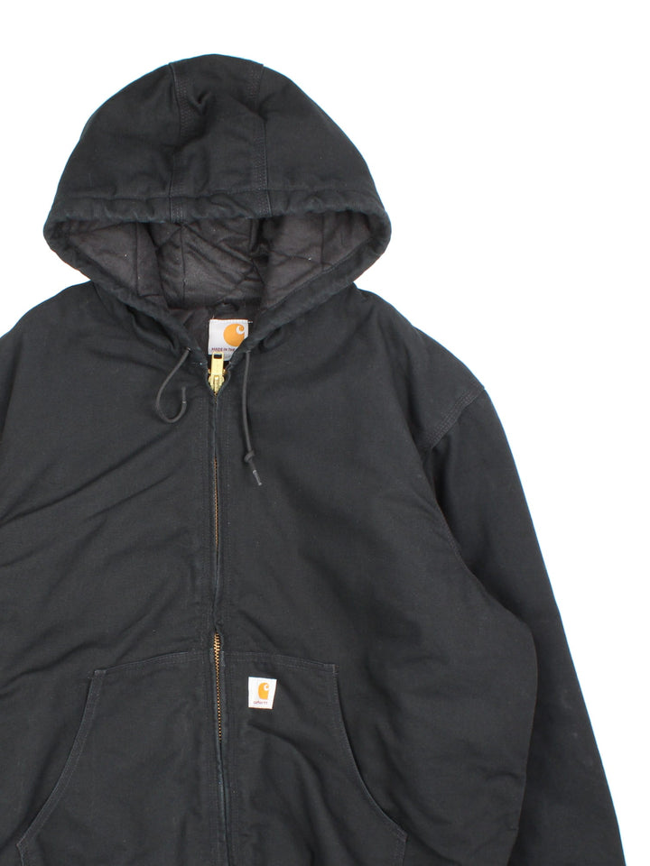 Vintage Carhartt Active Jacket in a black colourway. Zip up fastening, with hood and x 2 front pockets. Quilted lining with x 2 interior pockets and Carhartt branding on front. 