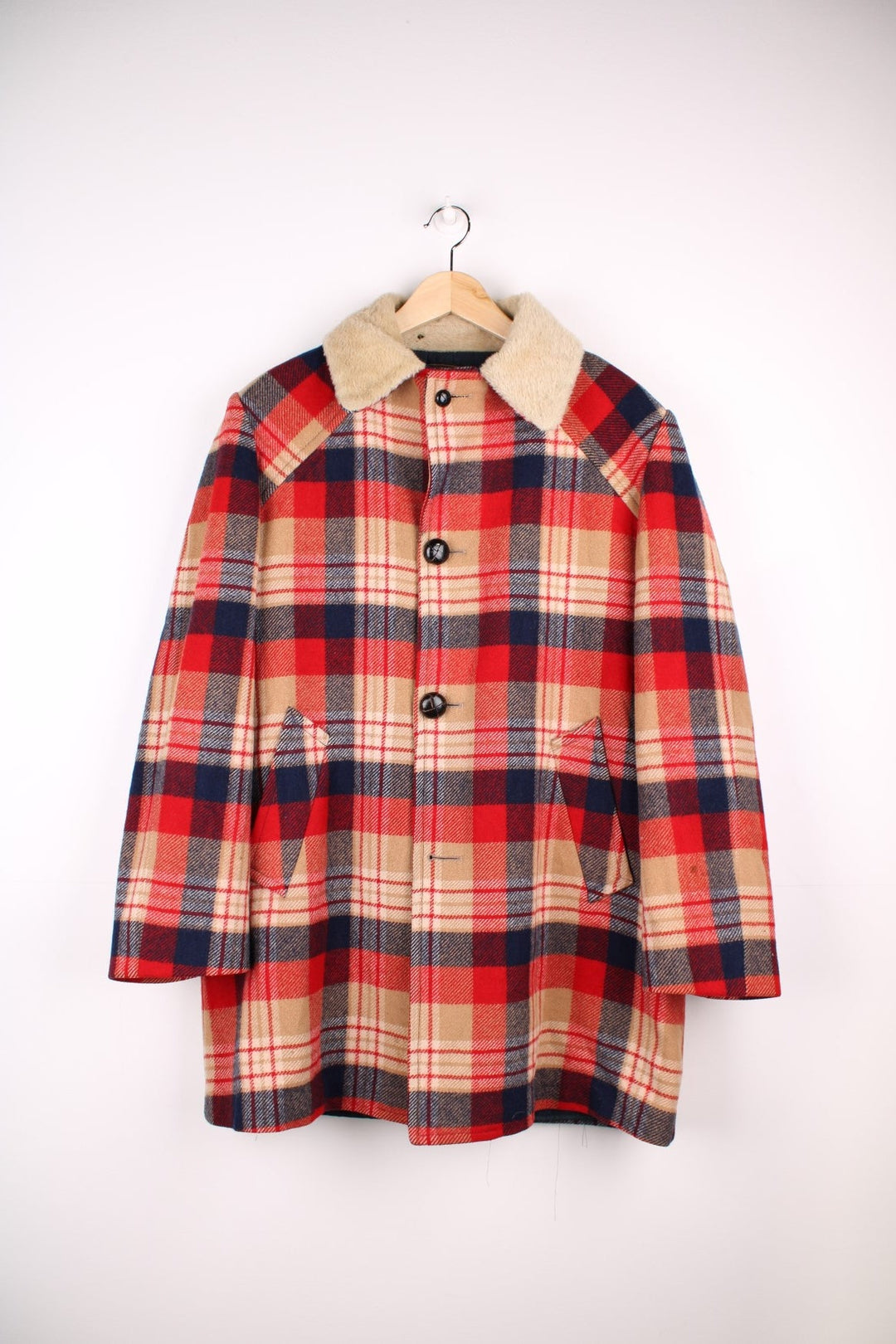 Vintage Pendleton coat in a red navy and cream checked Wool. The jacket has a faux fur collar, is lined with a quilted polyester, and has 2 jetted pockets on the front panels. Made in the USA. 