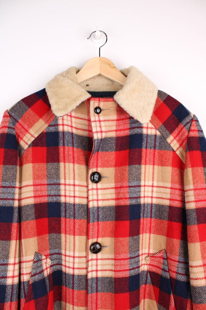 Vintage Pendleton coat in a red navy and cream checked Wool. The jacket has a faux fur collar, is lined with a quilted polyester, and has 2 jetted pockets on the front panels. Made in the USA. 