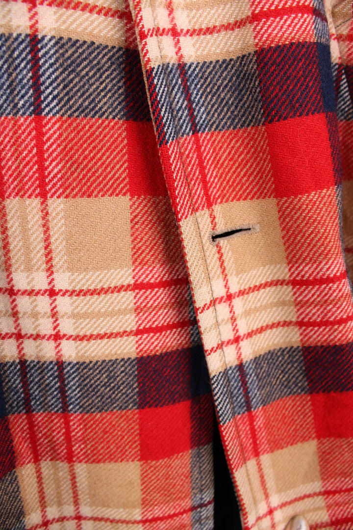 Vintage Pendleton coat in a red navy and cream checked Wool. The jacket has a faux fur collar, is lined with a quilted polyester, and has 2 jetted pockets on the front panels. Made in the USA. 