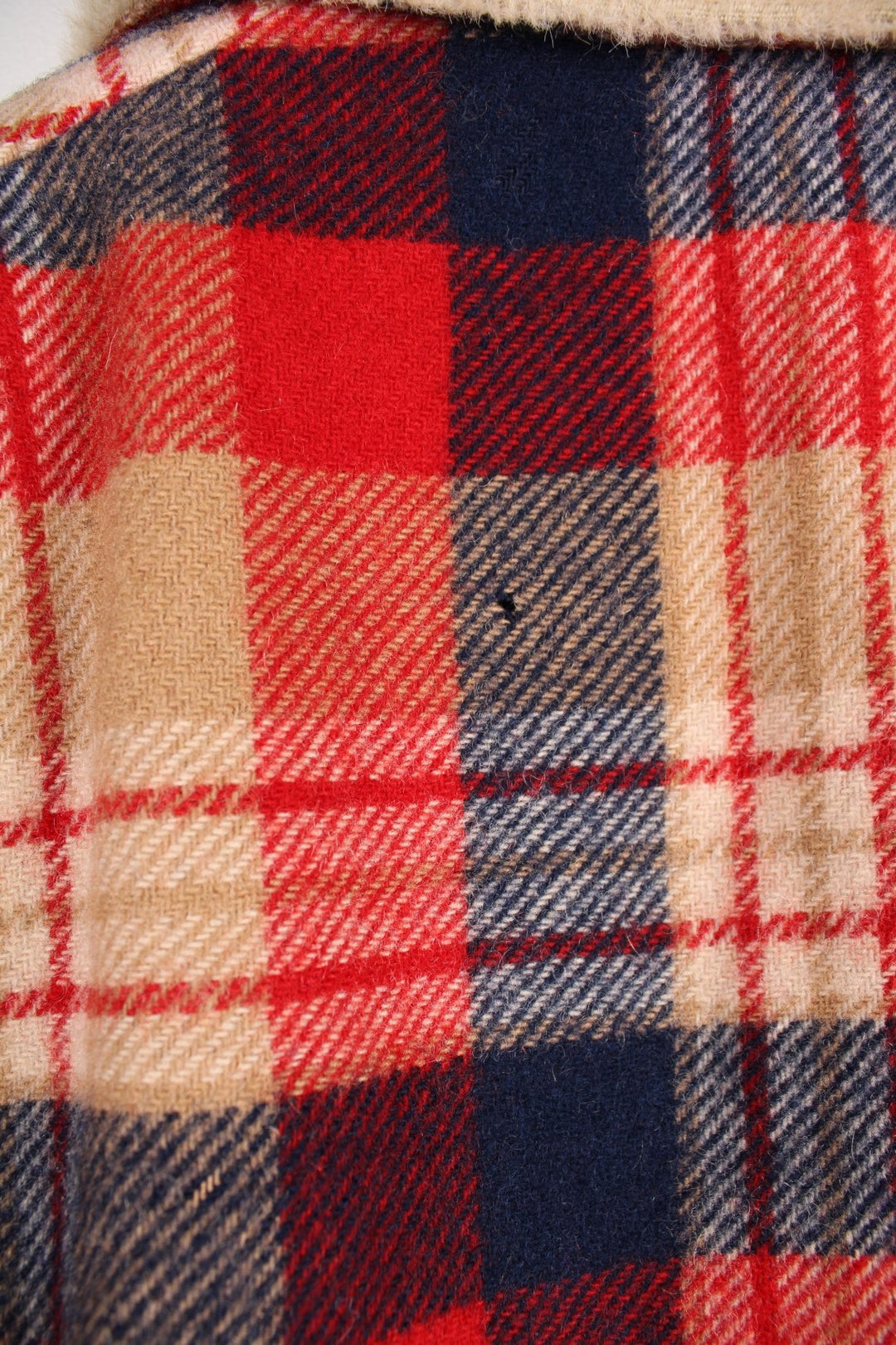 Vintage Pendleton coat in a red navy and cream checked Wool. The jacket has a faux fur collar, is lined with a quilted polyester, and has 2 jetted pockets on the front panels. Made in the USA. 