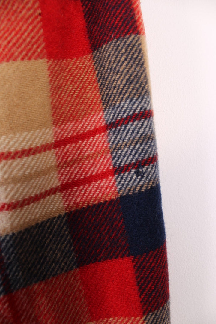 Vintage Pendleton coat in a red navy and cream checked Wool. The jacket has a faux fur collar, is lined with a quilted polyester, and has 2 jetted pockets on the front panels. Made in the USA. 