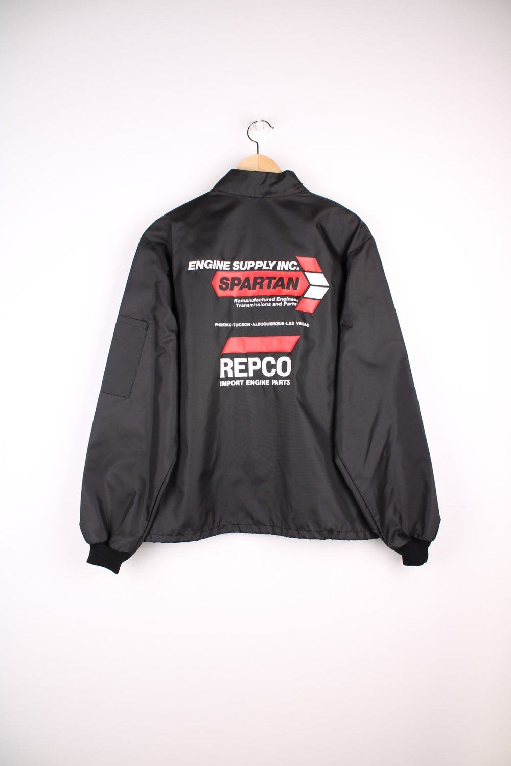 Vintage shell jacket in a black colourway. The jacket has a large printed logo on the back, and from the manufacturing of the jacket seems to date from the late 70s early 80s. Made in the USA. 