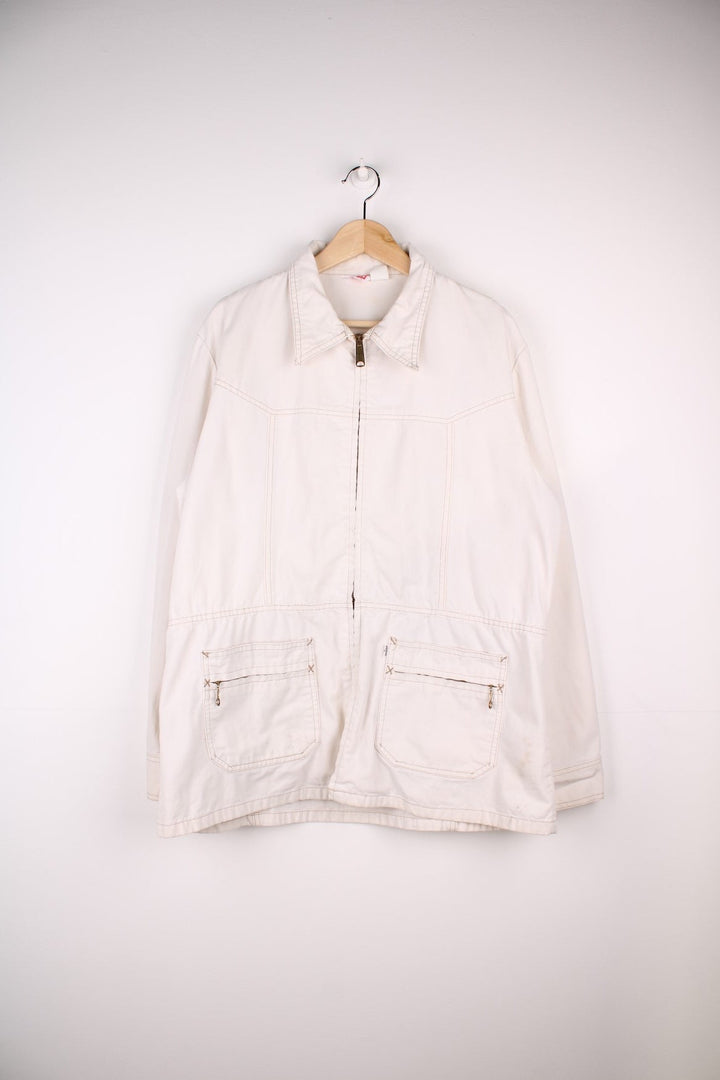 Vintage Levi Strauss chore jacket in an off white / cream colourway. Has a dagger collar and two zip pockets. Made in the USA. 