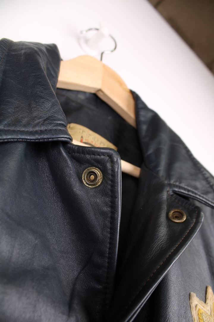 Vintage leather jacket in a dark navy blue colourway. The jacket has an Orillia Travelways patch, who were an Ice Hockey team based in Ontario Canada. It also has press studs to close, and jetted pockets on the front. Dates between 1970-78. Made in Canada. 