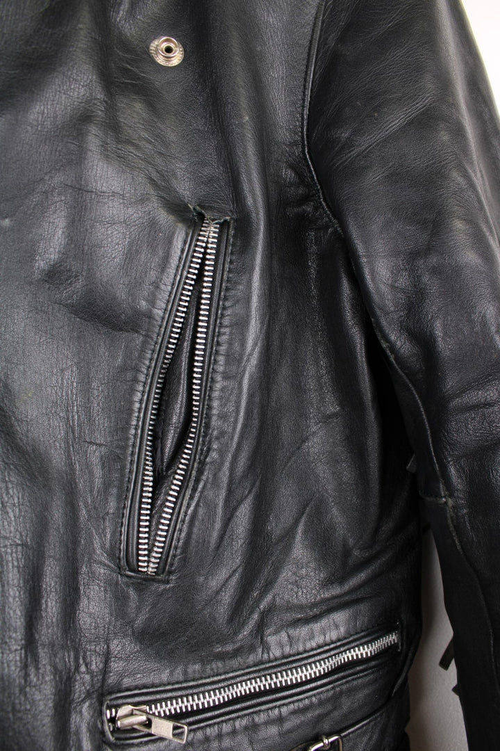 Vintage fringed motorcycle jacket in black. The jacket dates to the 1980s from the brand Drag Specialties. It is made from a heavyweight leather and has fringe up the seam of the sleeves and across the yoke panel. 