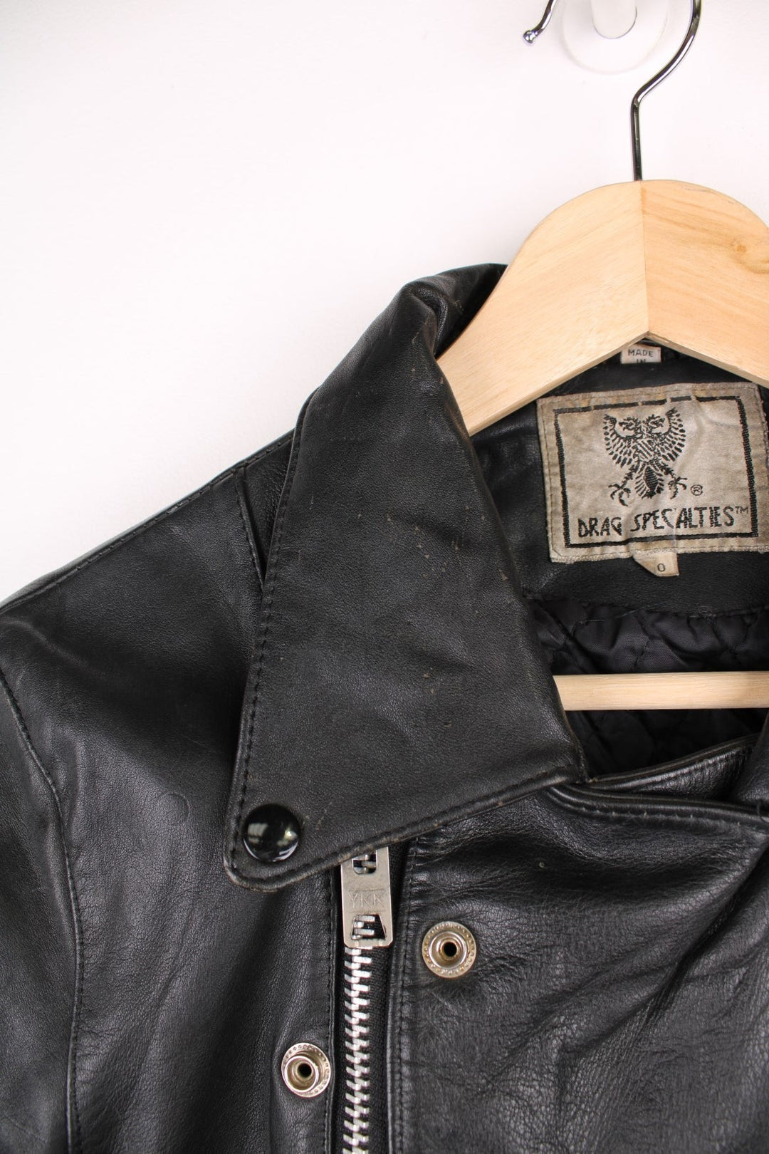 Vintage fringed motorcycle jacket in black. The jacket dates to the 1980s from the brand Drag Specialties. It is made from a heavyweight leather and has fringe up the seam of the sleeves and across the yoke panel. 