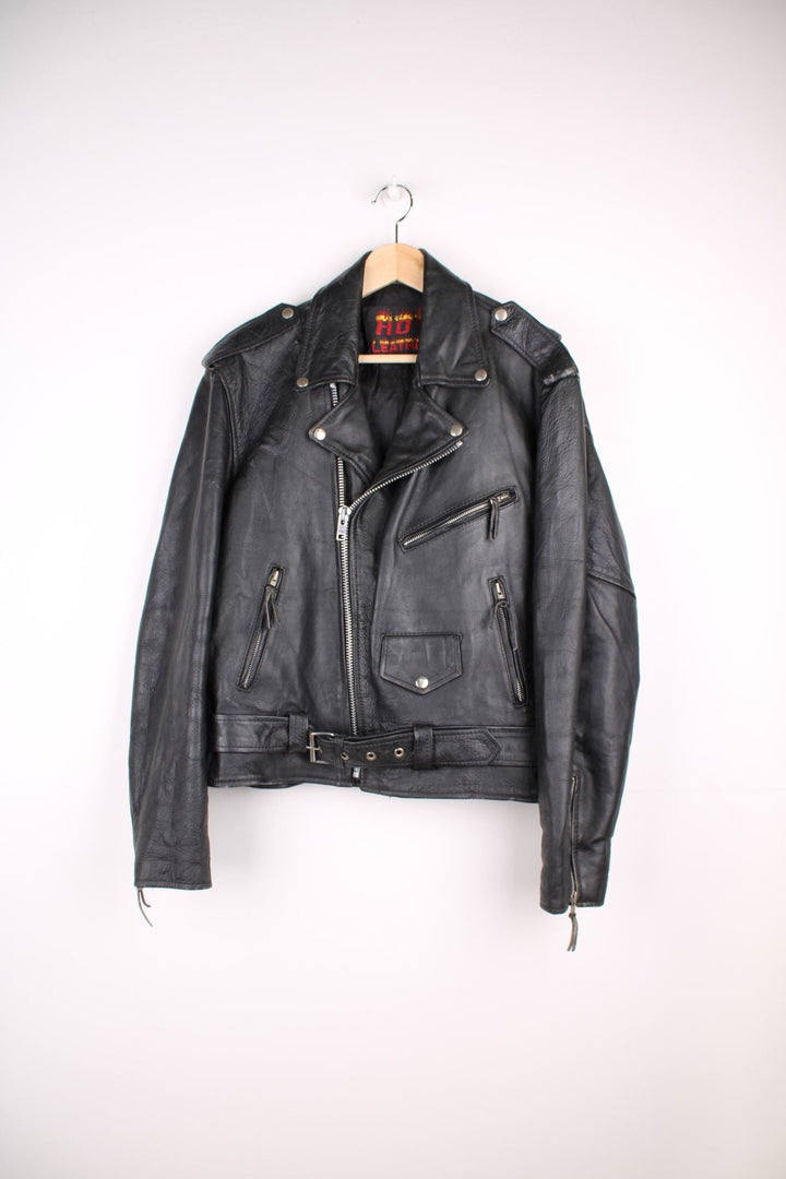 Vintage black leather motorcycle jacket. The interior label says Hot Leathers, and has lace up side panels, multiple pockets and a belt. 