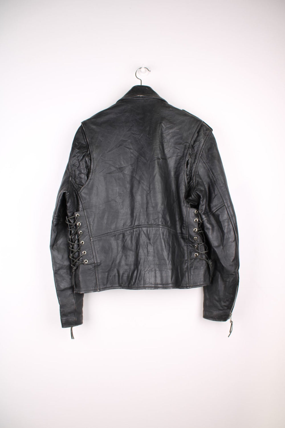 Vintage black leather motorcycle jacket. The interior label says Hot Leathers, and has lace up side panels, multiple pockets and a belt. 