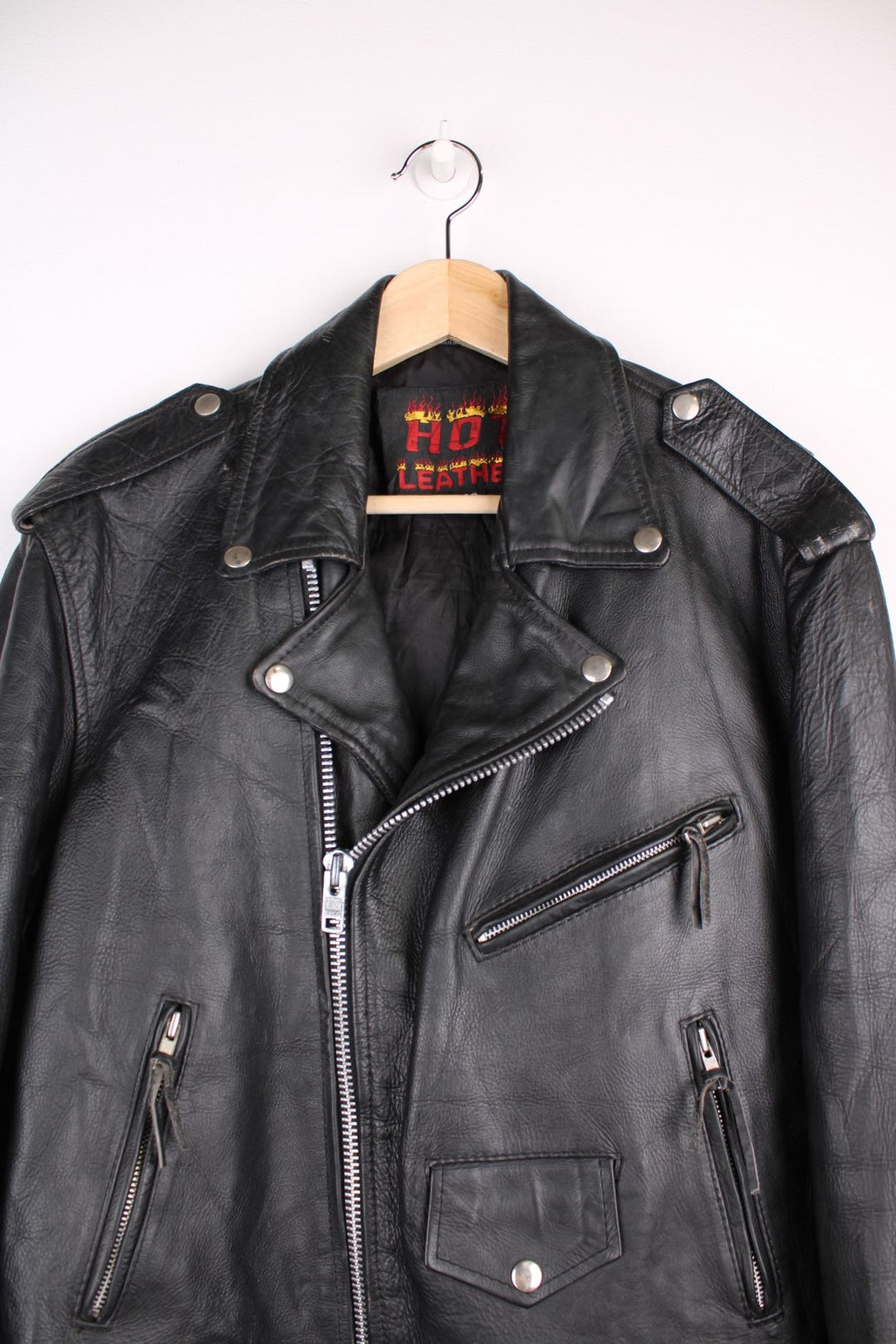 Vintage black leather motorcycle jacket. The interior label says Hot Leathers, and has lace up side panels, multiple pockets and a belt. 