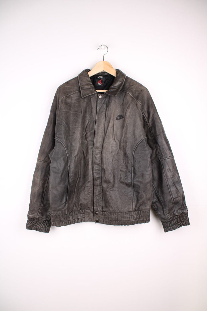 Vintage Nike Flight Air Jordan bomber jacket in brown. The jacket has the nike logo embroidered in black on the front, a large embroidered logo on the back, a zip to close and an interior pocket.  