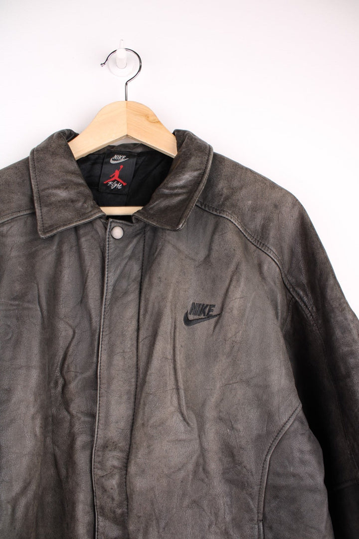 Vintage Nike Flight Air Jordan bomber jacket in brown. The jacket has the nike logo embroidered in black on the front, a large embroidered logo on the back, a zip to close and an interior pocket.  