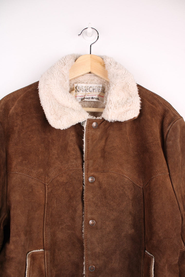 Vintage Schott Rancher Suede Trucker Jacket in brown. The jacket is fully lined with a cream fleece, has a western style yolk panelled front, and press studs to close.  