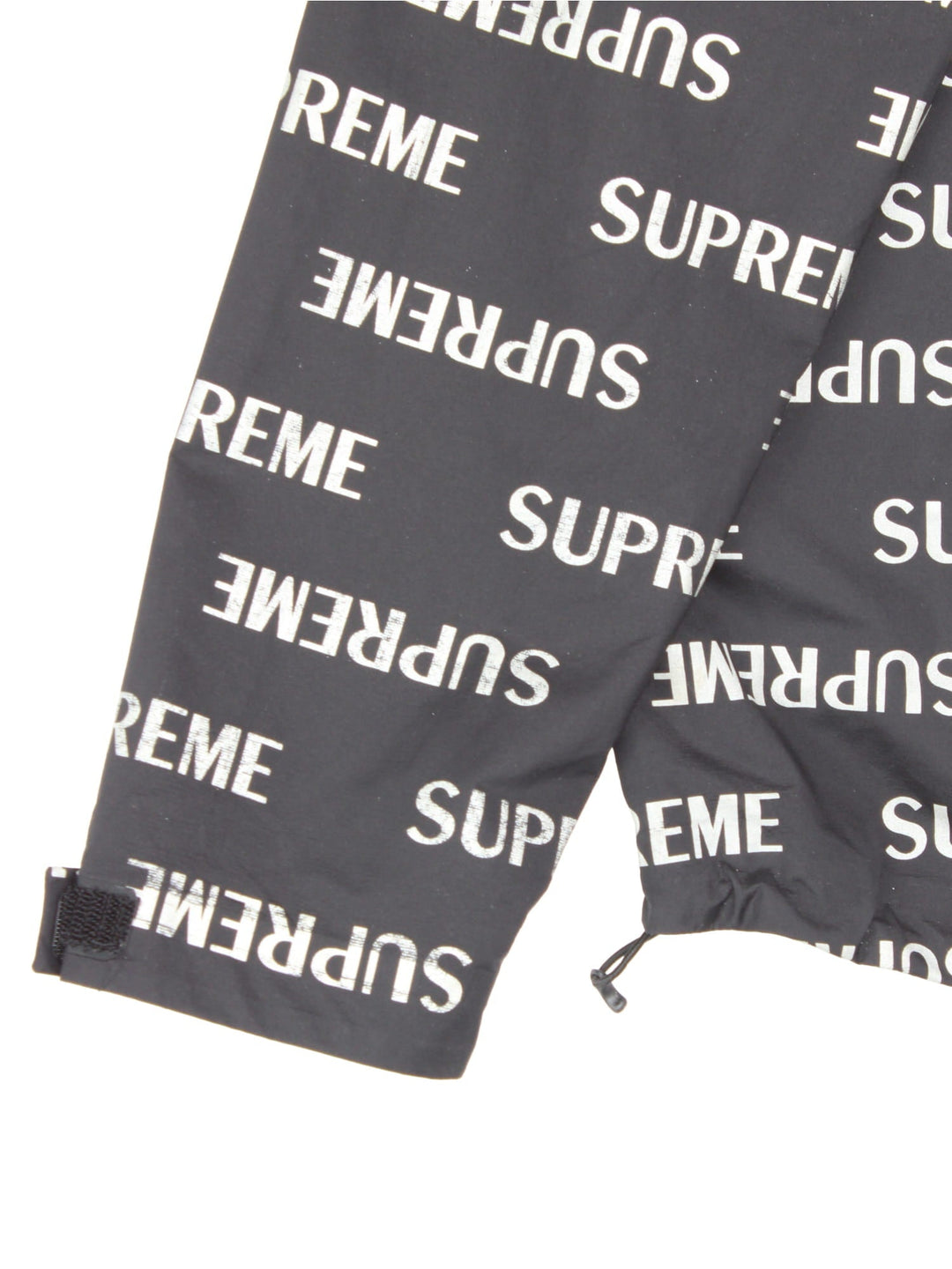 Supreme 3M reflective repeat logo taped seam waterproof jacket in black with zip and snap closure, and a hood with elastic toggle adjusters.