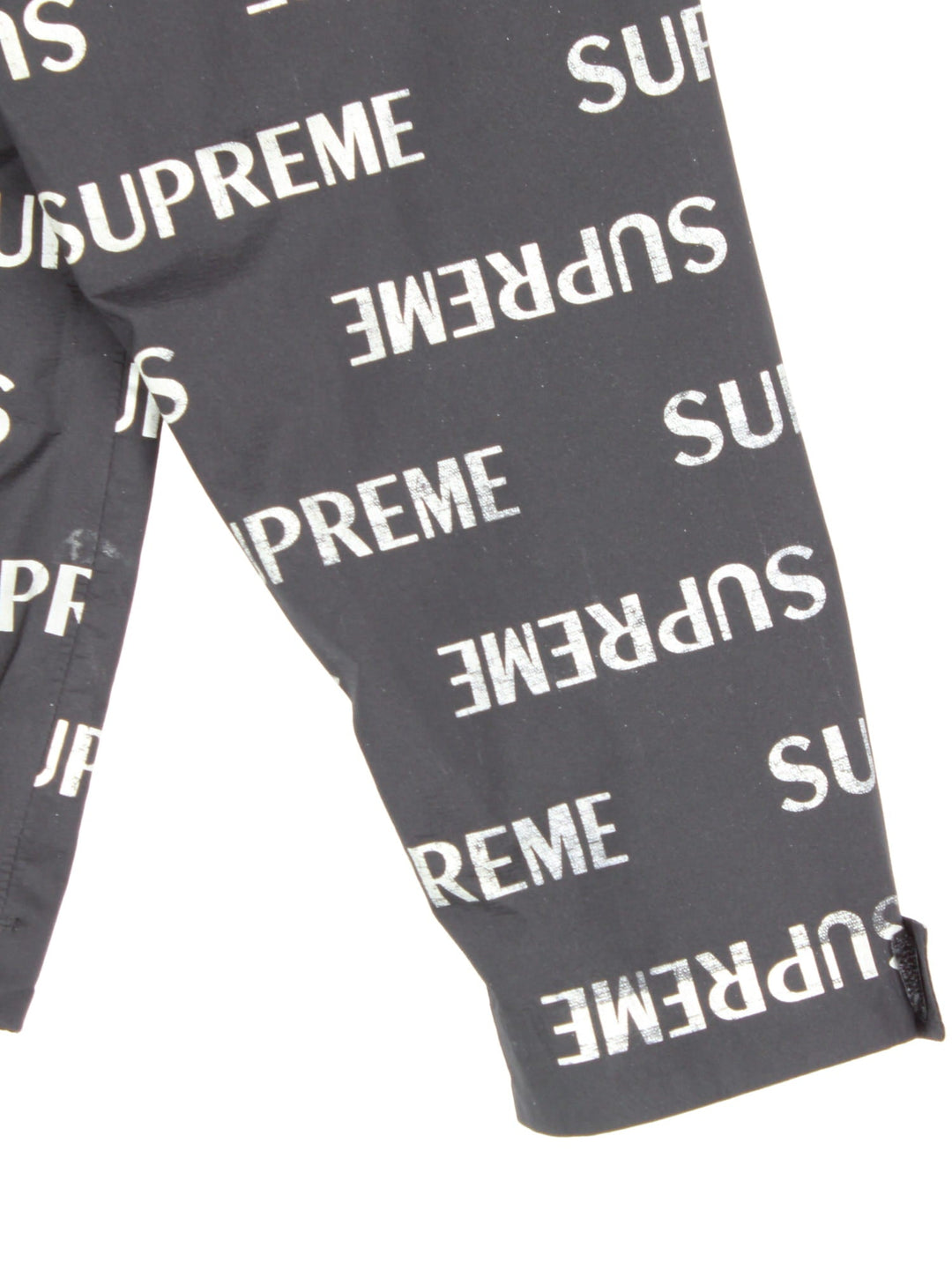 Supreme 3M reflective repeat logo taped seam waterproof jacket in black with zip and snap closure, and a hood with elastic toggle adjusters.