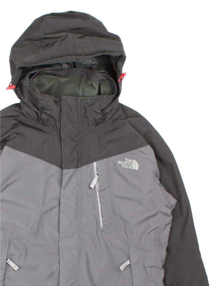 The North Face HyVent hooded jacket in grey with black hood and sleeves, multiple pockets, zip and velcro closure, toggle adjusters at the waist and neck, and embroidered logos on the front and sleeve.