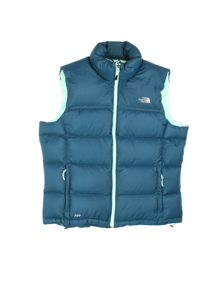 The North Face 700 down zip-through puffer gilet in blue with mint green lining and hardware, two zipped pockets, and embroidered logos front and back.