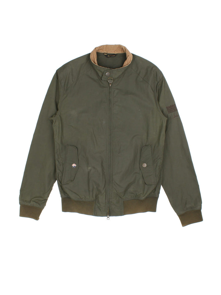 Barbour International Steve McQueen Harrington Jacket in a green colourway. Zips up and has side pockets, corduroy collar, and has the logo embroidered on the left sleeve.