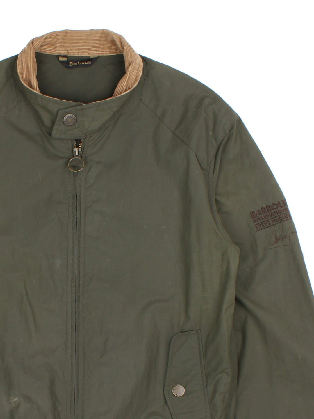 Barbour International Steve McQueen Harrington Jacket in a green colourway. Zips up and has side pockets, corduroy collar, and has the logo embroidered on the left sleeve.