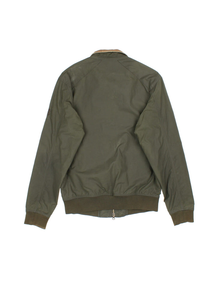 Barbour International Steve McQueen Harrington Jacket in a green colourway. Zips up and has side pockets, corduroy collar, and has the logo embroidered on the left sleeve.