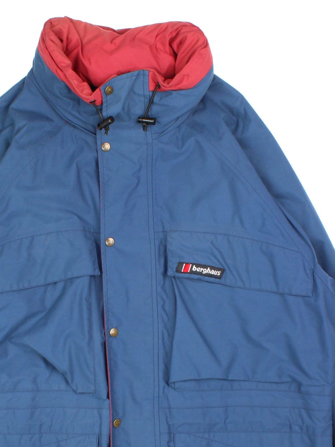 Vintage Berghaus Jacket in a blue colourway. Zips and buttons up, has multiple pockets, hidden hood, and the logo embroidered on the front.