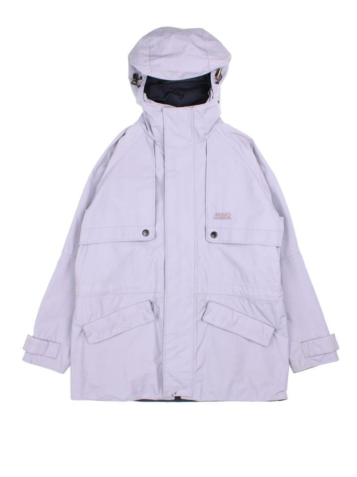 Vintage Musto Outdoors Jacket in a light purple colourway. Zips up and has multiple pockets, hidden hood, and has the logo embroidered on the front.