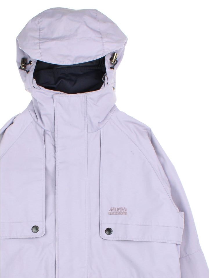 Vintage Musto Outdoors Jacket in a light purple colourway. Zips up and has multiple pockets, hidden hood, and has the logo embroidered on the front.