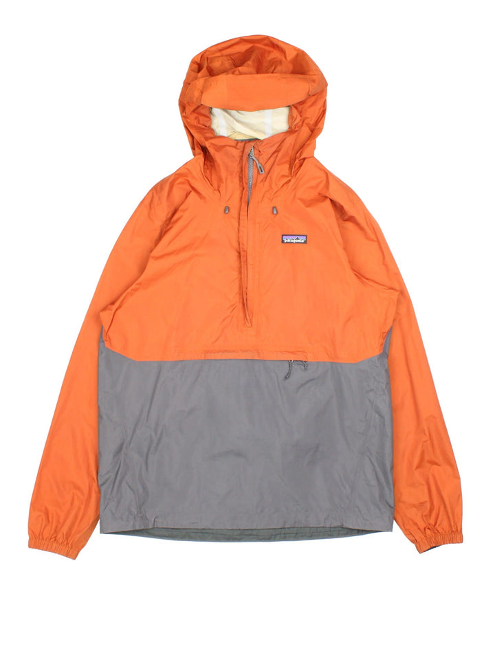 Patagonia Torrentshell Pullover Lightweight Jacket in a orange and grey colourway. Half zip up and has a big pouch pockets, hooded, and has the logo embroidered on the front.