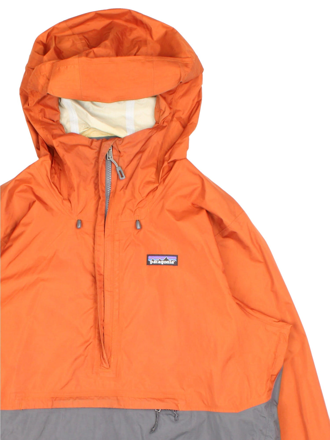 Patagonia Torrentshell Pullover Lightweight Jacket in a orange and grey colourway. Half zip up and has a big pouch pockets, hooded, and has the logo embroidered on the front.