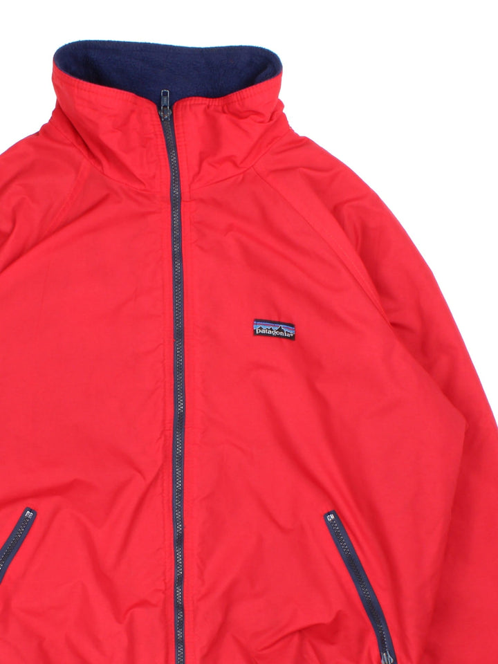 Vintage 90's Patagonia Bomber Jacket in a red colourway. Zips up and has side pockets, insulated with a fleece lining, and has the logo embroidered on the front.