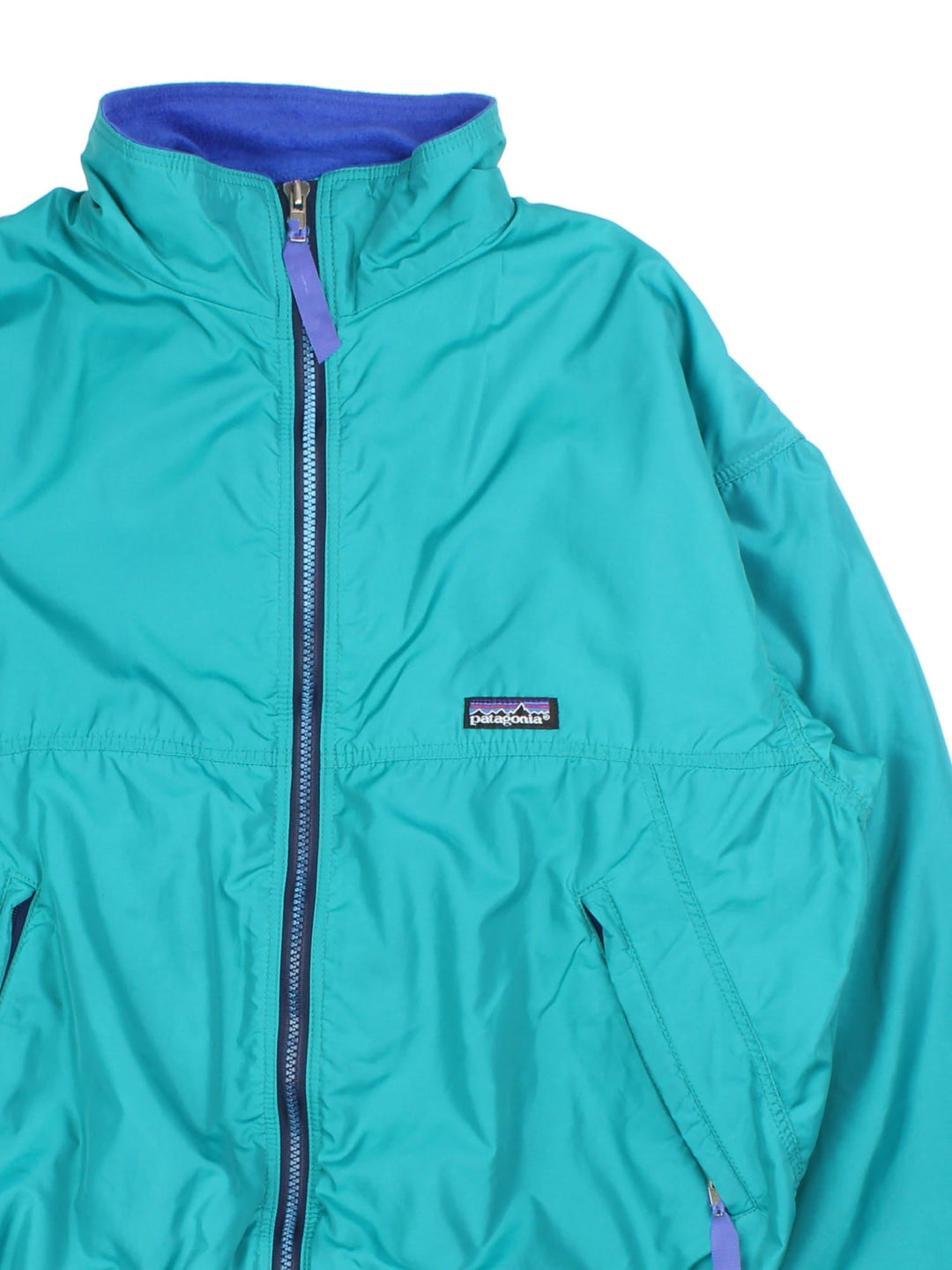 Vintage 90's Patagonia Bomber Jacket in a turquoise blue colourway. Zips up and has side pockets, insulated with a fleece lining, and has the logo embroidered on the front.