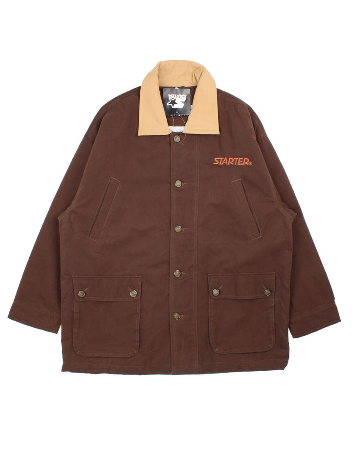 Starter Rugged Terrain Jacket in a brown colourway. Buttons up and has multiple pockets, insulated with a quilted lining, and has the logo embroidered on the front and back.