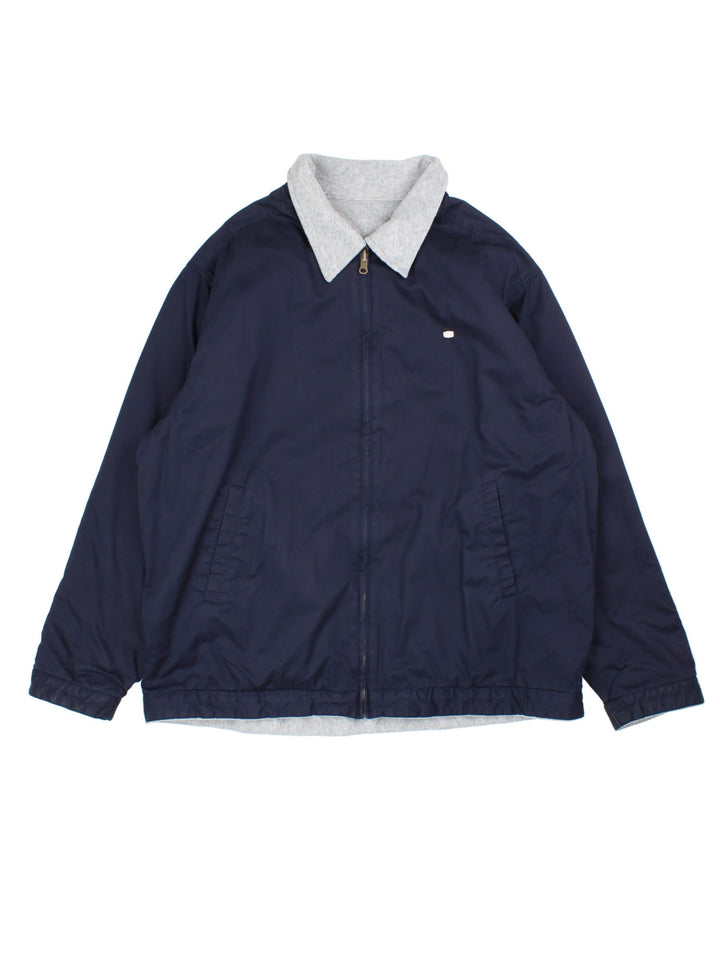 Lacoste Reversible Bomber Jacket in a blue and grey colourway with either jacket or fleece reversible options. Zips up and has side pockets, insulated lining, and has the logo embroidered on the front.