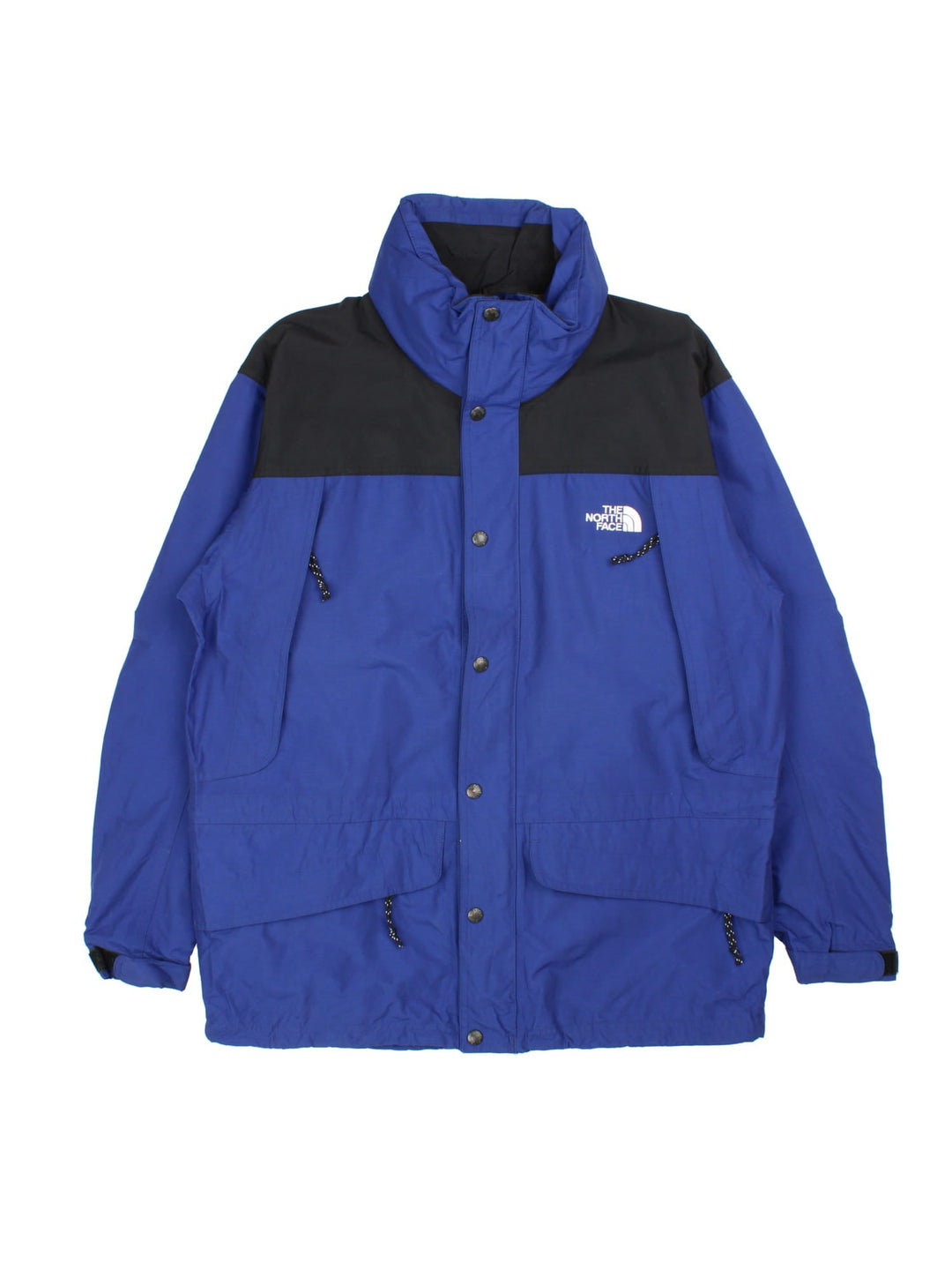 Vintage The North Face Mountain Jacket in a blue and black colourway. Zips an buttons up, has multiple pockets, hidden hood, and has the logo embroidered on the front and back.