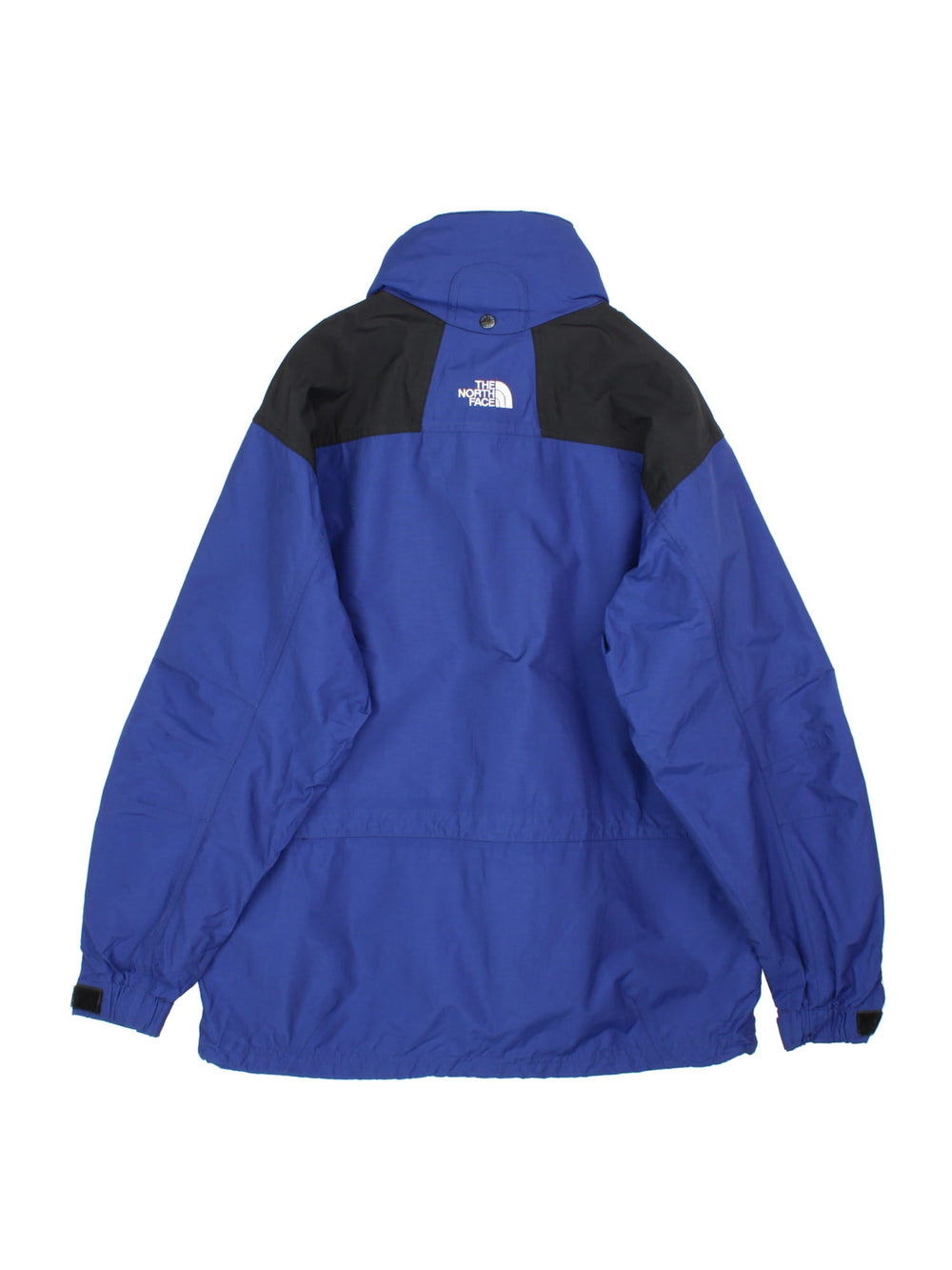 Vintage The North Face Mountain Jacket in a blue and black colourway. Zips an buttons up, has multiple pockets, hidden hood, and has the logo embroidered on the front and back.