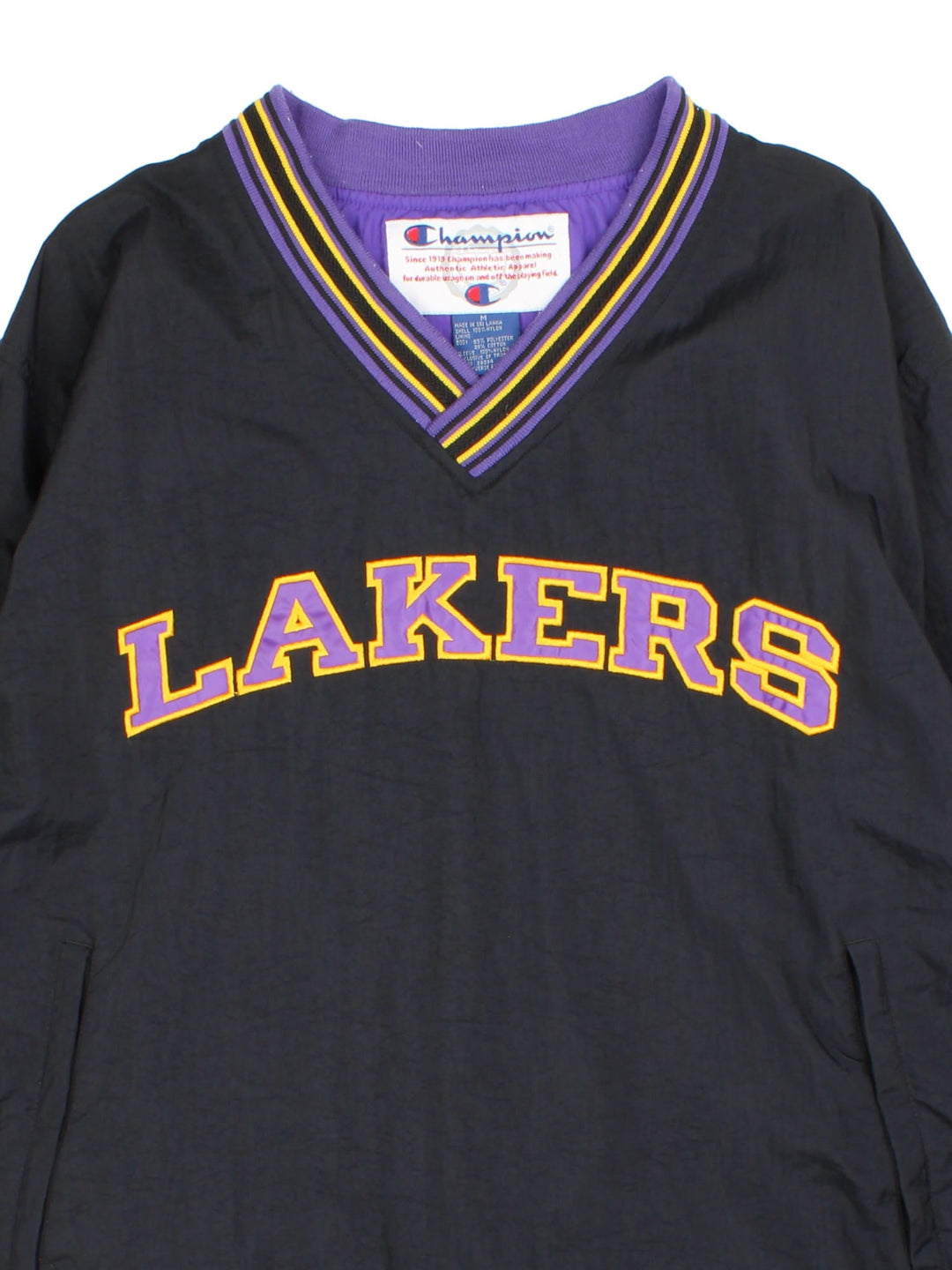 Vintage Champion Los Angeles Laker NBA Drill Training Top in a black colourway. Pullover with a v neck collar, has side pockets, and the team spell out logo embroidered on the front.