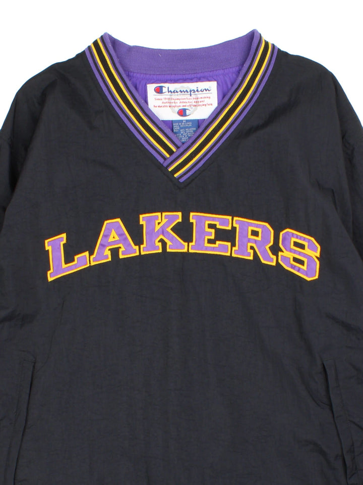 Vintage Champion Los Angeles Laker NBA Drill Training Top in a black colourway. Pullover with a v neck collar, has side pockets, and the team spell out logo embroidered on the front.