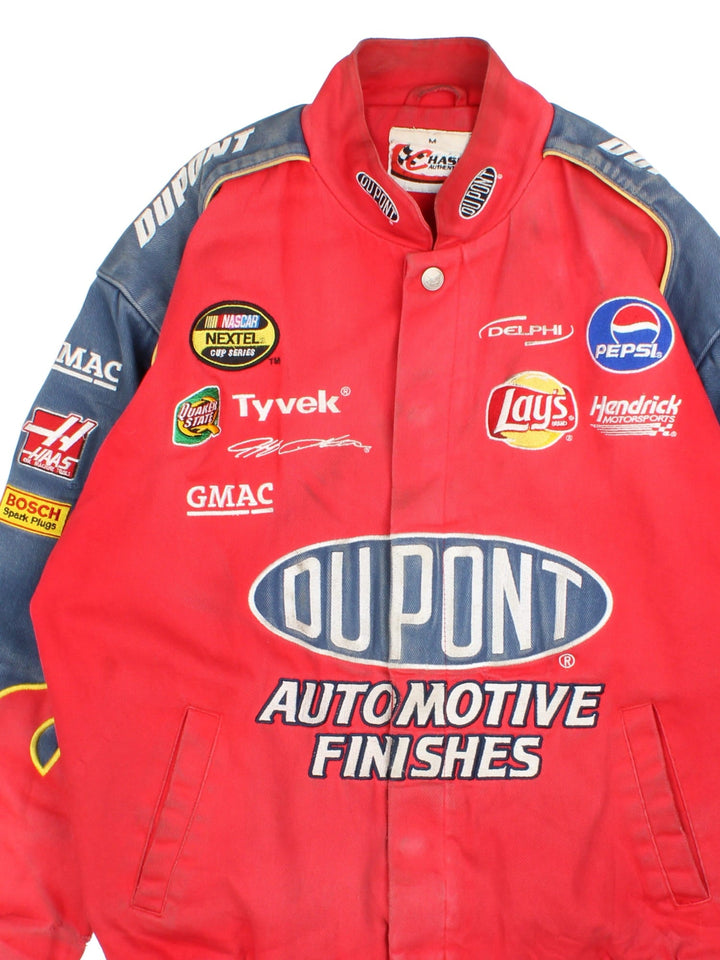 Vintage Dupont Nascar Jacket in a red colourway. Buttons up and has side pockets, and the logos and sponsors embroidered on the front and back.