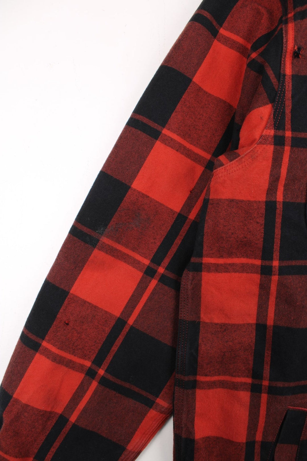 Carhartt Flannel Shirt Jacket in a red and black plaid colourway. Buttons up and has double chest pockets, insulated with a sherpa lining, and has the logo embroidered on the front.