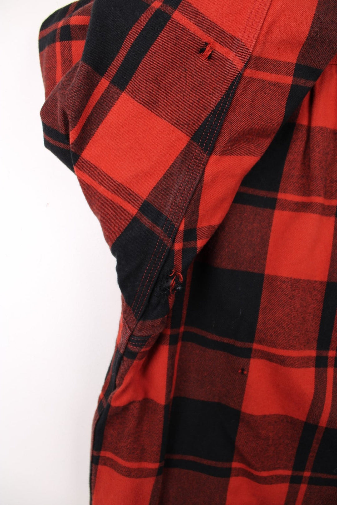 Carhartt Flannel Shirt Jacket in a red and black plaid colourway. Buttons up and has double chest pockets, insulated with a sherpa lining, and has the logo embroidered on the front.