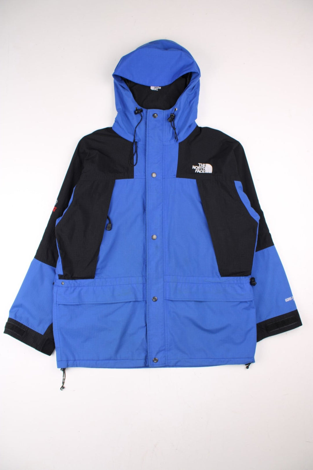 Vintage The North Face Gore-Tex Summit Series Jacket in a blue and black colourway. Zip and buttons up, has multiple pockets, mesh lining, hooded, and the logo embroidered on the front and back.