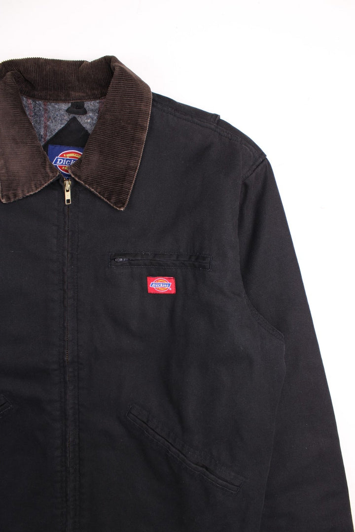 Vintage Dickies Detroit Work Jacket in a black colourway with a brown corduroy collar. Zips up and has multiple pockets, blanket lining, and has the logo embroidered on the front.