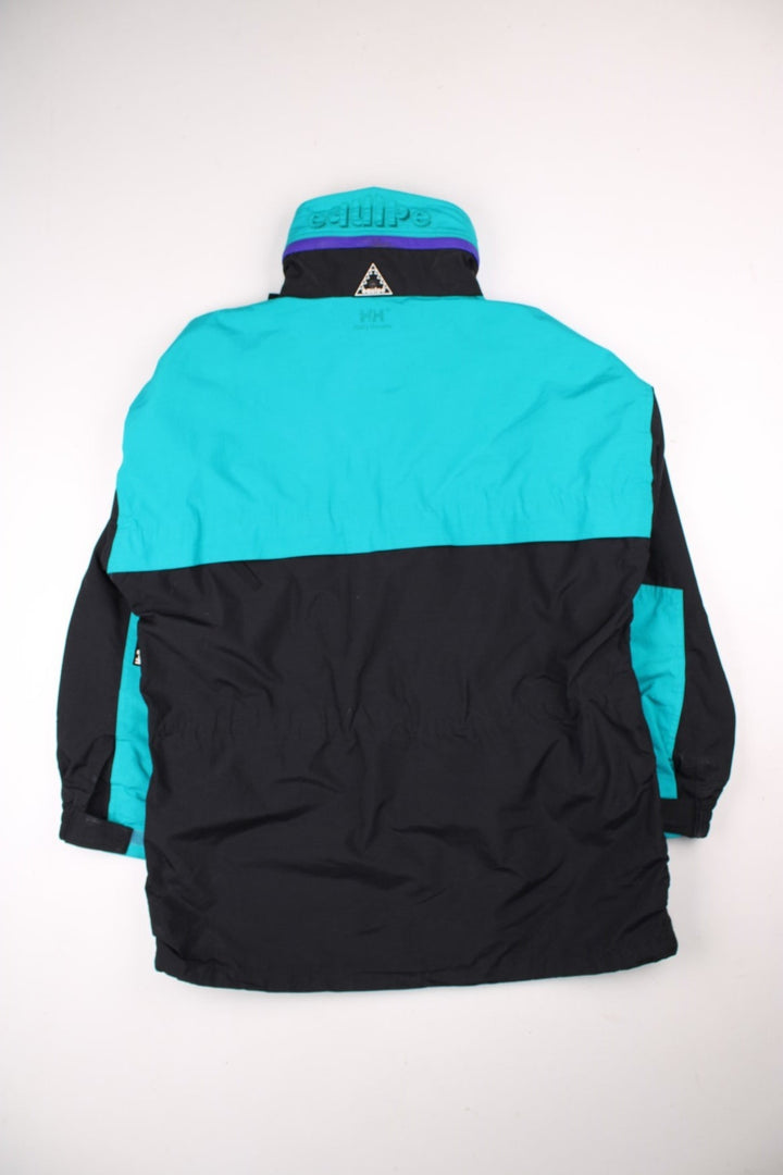 Vintage Helly Hansen Equipe Jacket in a black and blue colourway. Zip and buttons up, has multiple pockets, mesh lining, and has the logos embroidered on the front and left sleeve.