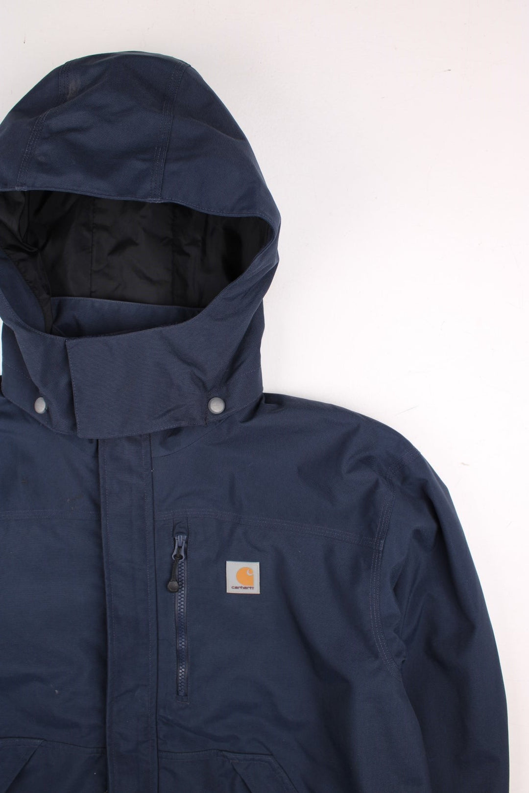 Carhartt Shoreline Jacket in a navy blue colourway. Zips up and has multiple pockets, detachable hood, mesh lining, and has the logo embroidered on the front.