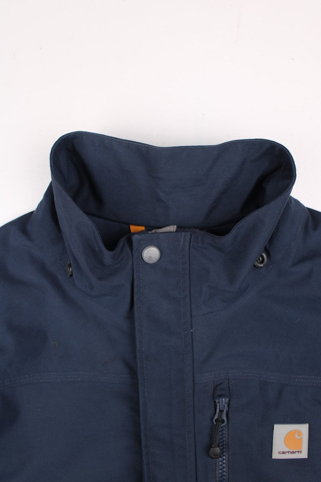 Carhartt Shoreline Jacket in a navy blue colourway. Zips up and has multiple pockets, detachable hood, mesh lining, and has the logo embroidered on the front.