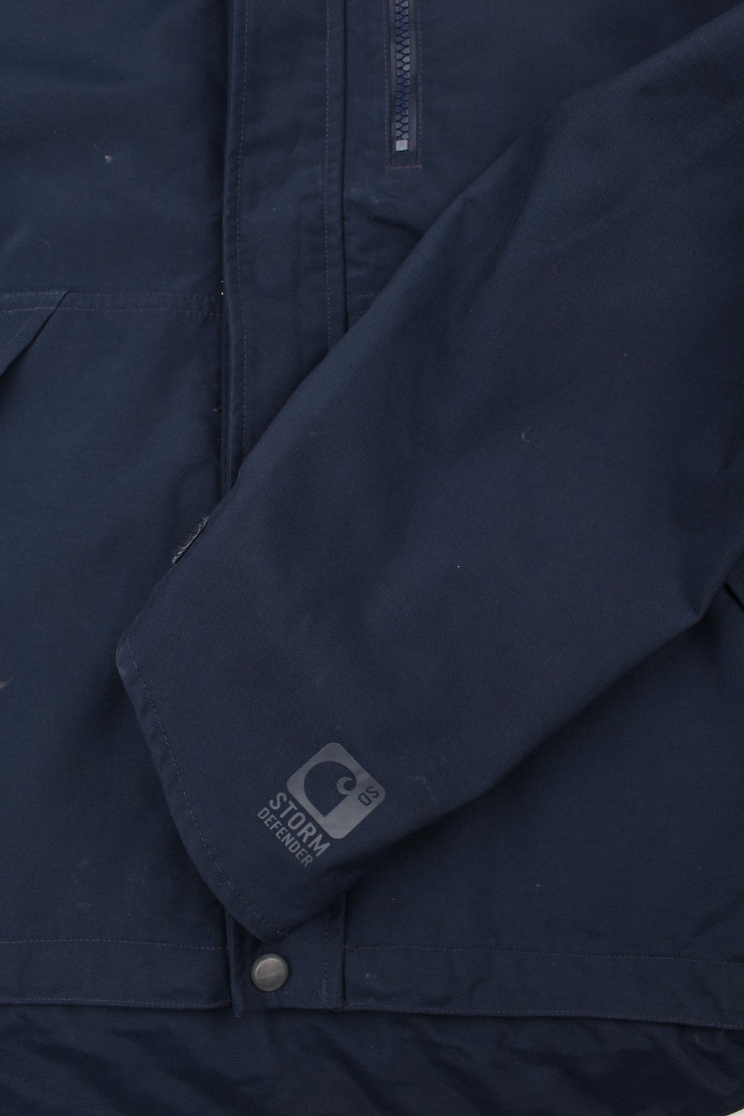 Carhartt Shoreline Jacket in a navy blue colourway. Zips up and has multiple pockets, detachable hood, mesh lining, and has the logo embroidered on the front.