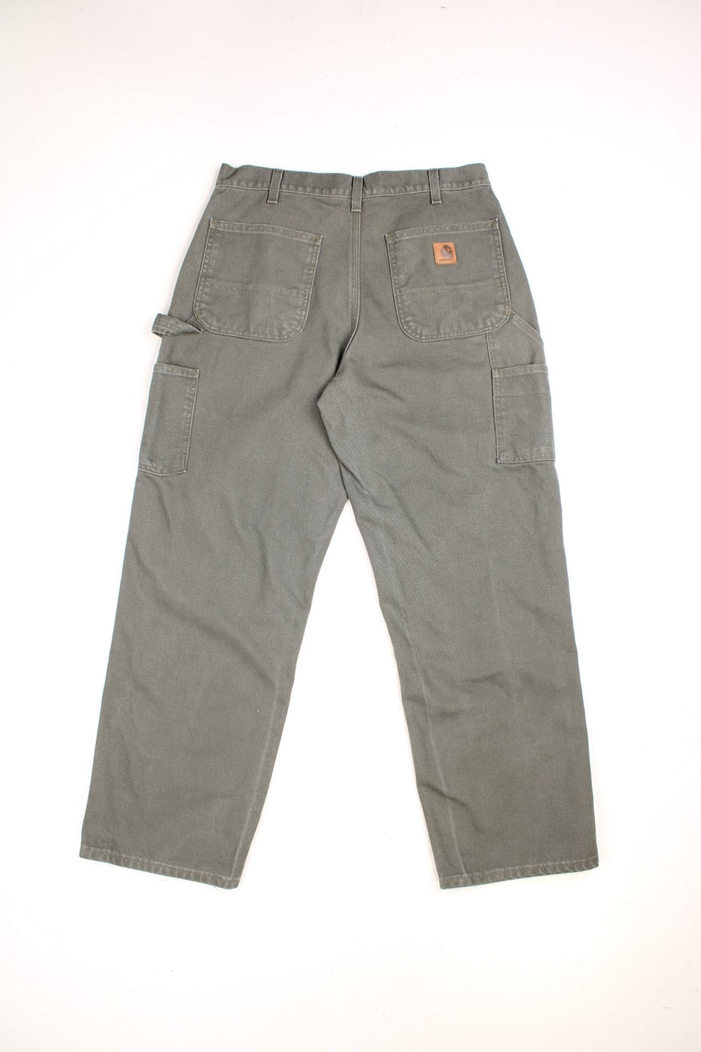 Carhartt carpenter jeans in green with multiple pockets and a logo patch on the back.